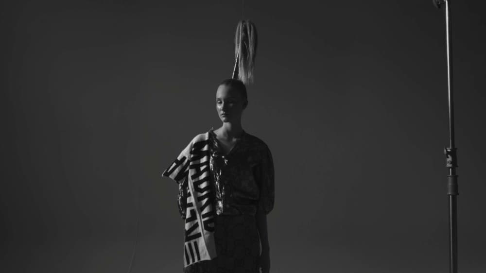 Black-and-white fashion model framed on a visible studio set for White Light
